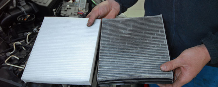 one new cabin air filter & one dirty cabin air filter hold by a person
