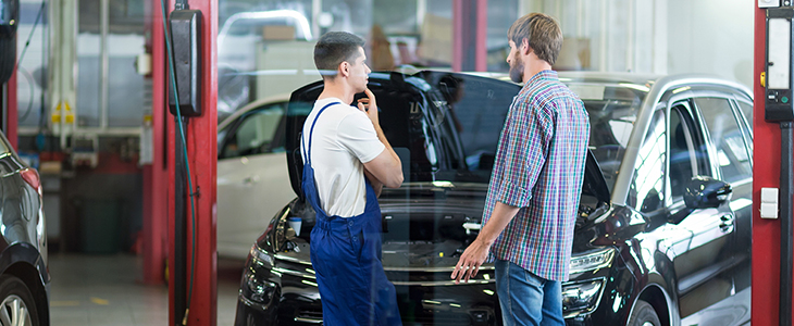 Car mechanic is talking with his client